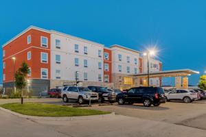 a parking lot with cars parked in front of a building at Best Western Plus Eastgate Inn & Suites in Regina