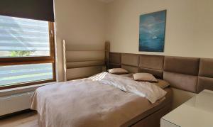 uma cama num quarto com uma grande janela em Comfort Warszawa em Varsóvia