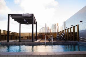 a swimming pool with a city skyline in the background at Mardisa Design #609 - Apto Deluxe por Carpediem in Tambaú