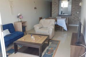 a living room with a couch and a table at Hermoso apartamento a pasos de la playa in Coquimbo
