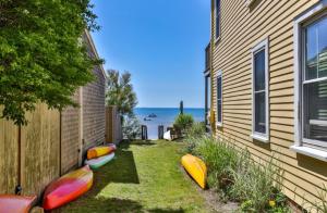 a row of kayaks sitting on the grass next to a house at Penthouse on Commercial in Provincetown