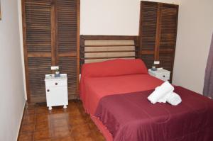 um quarto com uma cama vermelha e duas mesas de cabeceira em Lo de Annie Depto 2 em Posadas