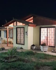 uma pequena casa com duas janelas e algumas plantas em Encanto Rural - Casa de campo para disfrutar y olvidar el estrés em Putaendo