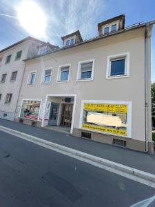 a white building with a store window on a street at LevelUp 2 Living Graz m. SelfCheckIn in Graz