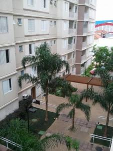 an apartment building with palm trees in front of it at Lindo apartamento a passos do Expo Center Norte in Sao Paulo