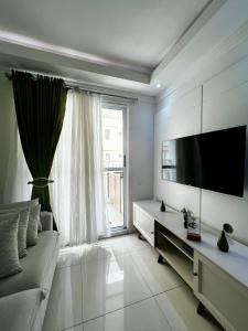 a living room with a tv and a large window at Lindo apartamento a passos do Expo Center Norte in São Paulo