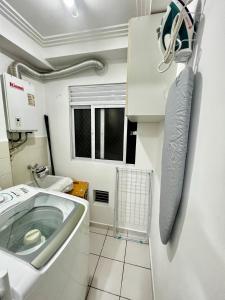 a bathroom with a sink and a washing machine at Lindo apartamento a passos do Expo Center Norte in São Paulo
