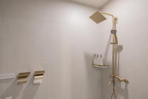 uma cabina de duche na casa de banho com azulejos brancos em 동래 덴바스타 호텔 em Busan