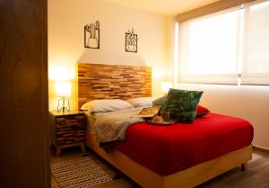 een slaapkamer met een bed met een rode sprei bij Kolben Nuoma in Mexico-Stad