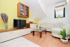 a living room with a couch and a tv at Apartments by the sea Vela Luka, Korcula - 9244 in Vela Luka