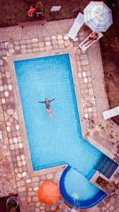 a person swimming in a large swimming pool at Pousada Di Luna in Bonito