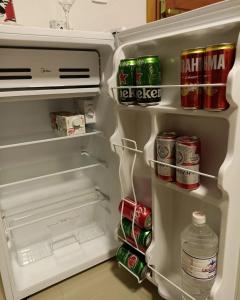 an open refrigerator filled with drinks and soda at Chalés por do sol in Pirenópolis