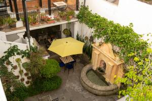 Hotel La Villa Serena في أنتيغوا غواتيمالا: إطلالة علوية على فناء فيه مظلة وطاولة
