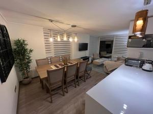 eine Küche und ein Wohnzimmer mit einem Tisch und Stühlen in der Unterkunft Departamento Nuevo Papudo - Full equipado - 7 personas in Papudo