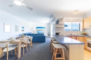 cocina y sala de estar con mesa y sofá en Kiah, 12,53 Victoria Pde - Panoramic water views, Wifi and Air Con en Nelson Bay