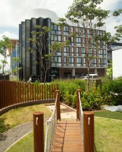 a wooden bridge in front of a building at Residencias Cityzen cerca del Aeropuerto in Echeverría