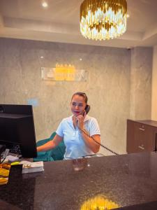 Een vrouw die op een mobieltje praat in een kantoor. bij Hotel Qatar Cali in Cali