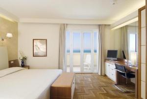 a hotel room with a bed and a view of the ocean at Grand Hotel & Riviera in Lido di Camaiore
