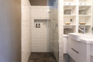 uma casa de banho branca com um chuveiro e 2 lavatórios. em Henry’s on Balfour - Historic understated luxury em Launceston