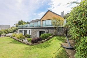 a house with a large yard in front of it at Trem Y Borth Apartment in Abersoch
