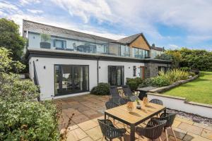 a house with a patio with a table and chairs at Trem Y Borth Apartment in Abersoch