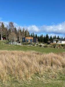 a house in the middle of a field at Boutique Tiny House - Te Anau Country Accommodation in Te Anau