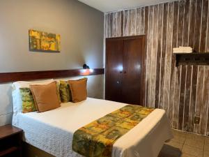 um quarto com uma cama num quarto em Pousada do Grilo em Santo Antônio do Pinhal