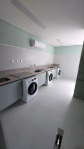 a kitchen with two washing machines in a room at Apartamento Smart Costa Azul in Salvador