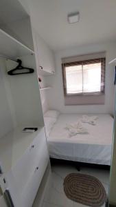 a small bedroom with a bed and a window at Apartamento Smart Costa Azul in Salvador