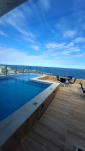 a swimming pool with a view of the ocean at Apartamento Smart Costa Azul in Salvador