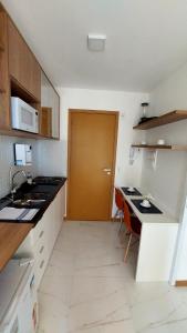 a small kitchen with a desk and a door at Apartamento Smart Costa Azul in Salvador