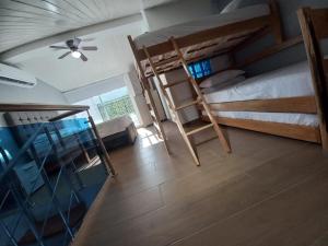 Cette chambre comprend 2 lits superposés et un ventilateur de plafond. dans l'établissement Apartamento dúplex vacacional cerca a la playa, à Gaira