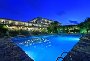 a swimming pool in front of a building at night at Sitia Beach City Resort & Spa in Sitia