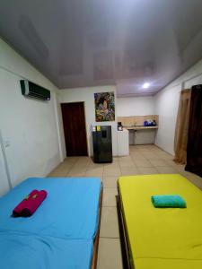 Cette chambre comprend deux lits et une cuisine équipée d'un réfrigérateur. dans l'établissement Ballena Oasis Homes( Dep Estudio con AC), à Uvita