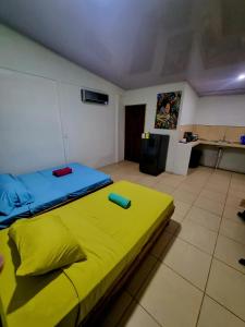 - une chambre avec un lit et une couverture jaune dans l'établissement Ballena Oasis Homes( Dep Estudio con AC), à Uvita