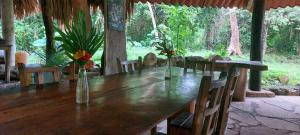 Lacanjá的住宿－Eco Hotel Sak Nok，一张木桌,上面有椅子和花瓶