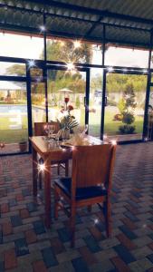 Quinta San Felipe في تابابيلا: طاولة وكراسي خشبية مع إضاءة على الفناء