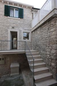 een trap naar een stenen gebouw met een raam bij Apartments Sonja in Pučišća