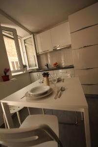 een witte tafel met een bord erop in de keuken bij Apartments Sonja in Pučišća