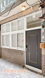 a building with white windows and a door at HoHo Woo Tainan Homestay in Tainan