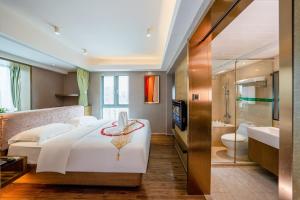 a bedroom with a large white bed and a bathroom at Fietser International Residence in Shenzhen