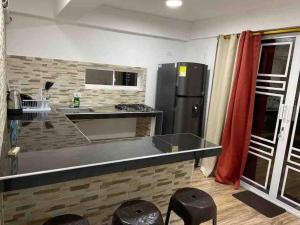 uma cozinha com um balcão com bancos e um frigorífico em POSADA VILLA BRYAN em Providencia