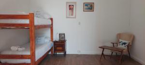 坦迪爾的住宿－Hostel B&B Tandil，一间卧室配有两张双层床和椅子
