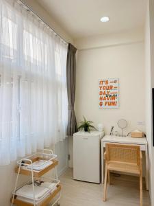 a room with a desk and a sink and a window at HoHo Woo Tainan Homestay in Tainan