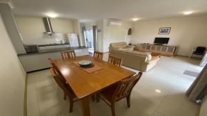 a dining room and living room with a table and chairs at Unit 63 Seafront Estate in Jurien Bay