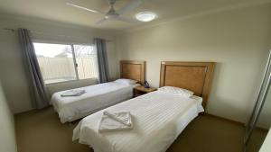 a room with two beds and a window at Unit 63 Seafront Estate in Jurien Bay +8 photos
