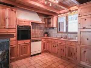 eine Küche mit Holzschränken und einem weißen Herd mit Backofen in der Unterkunft Appartement Chalet Spacieux 6 Pièces, Wi-Fi, Vue Panoramique - FR-1-275-148 in Montvalezan