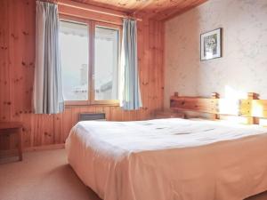 ein Schlafzimmer mit einem großen weißen Bett und einem Fenster in der Unterkunft Appartement Chalet Spacieux 6 Pièces, Wi-Fi, Vue Panoramique - FR-1-275-148 in Montvalezan