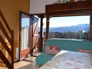 sypialnia z łóżkiem i balkonem z widokiem na góry w obiekcie Appartement cosy avec mezzanine et parking, proche des pistes - FR-1-592-47 w mieście Bolquere Pyrenees 2000