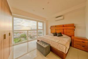 a bedroom with a bed and a large window at ¡Hermoso Condo con espectacular vista a la bahia!! in Puerto Vallarta